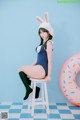 A woman in a bunny costume sitting on a stool.