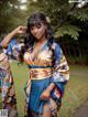 A woman in a blue and gold kimono posing for a picture.