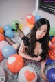 A woman laying on the floor surrounded by balloons.